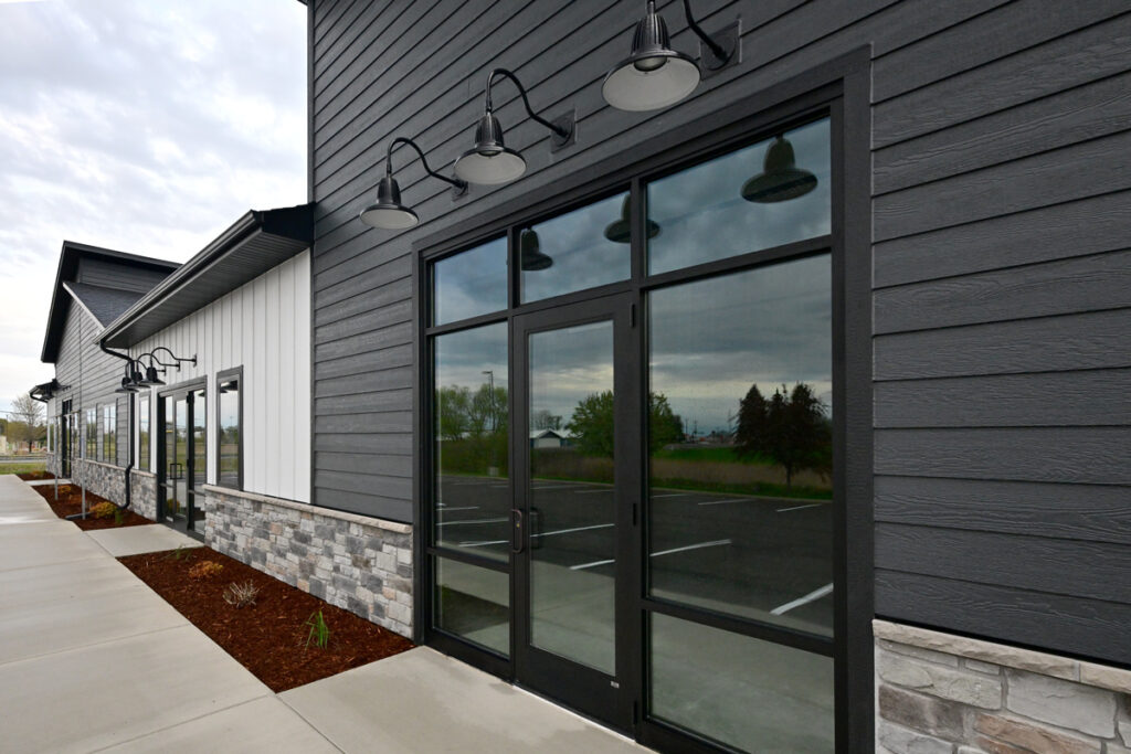 A white and gray professional building with a stone wainscot.