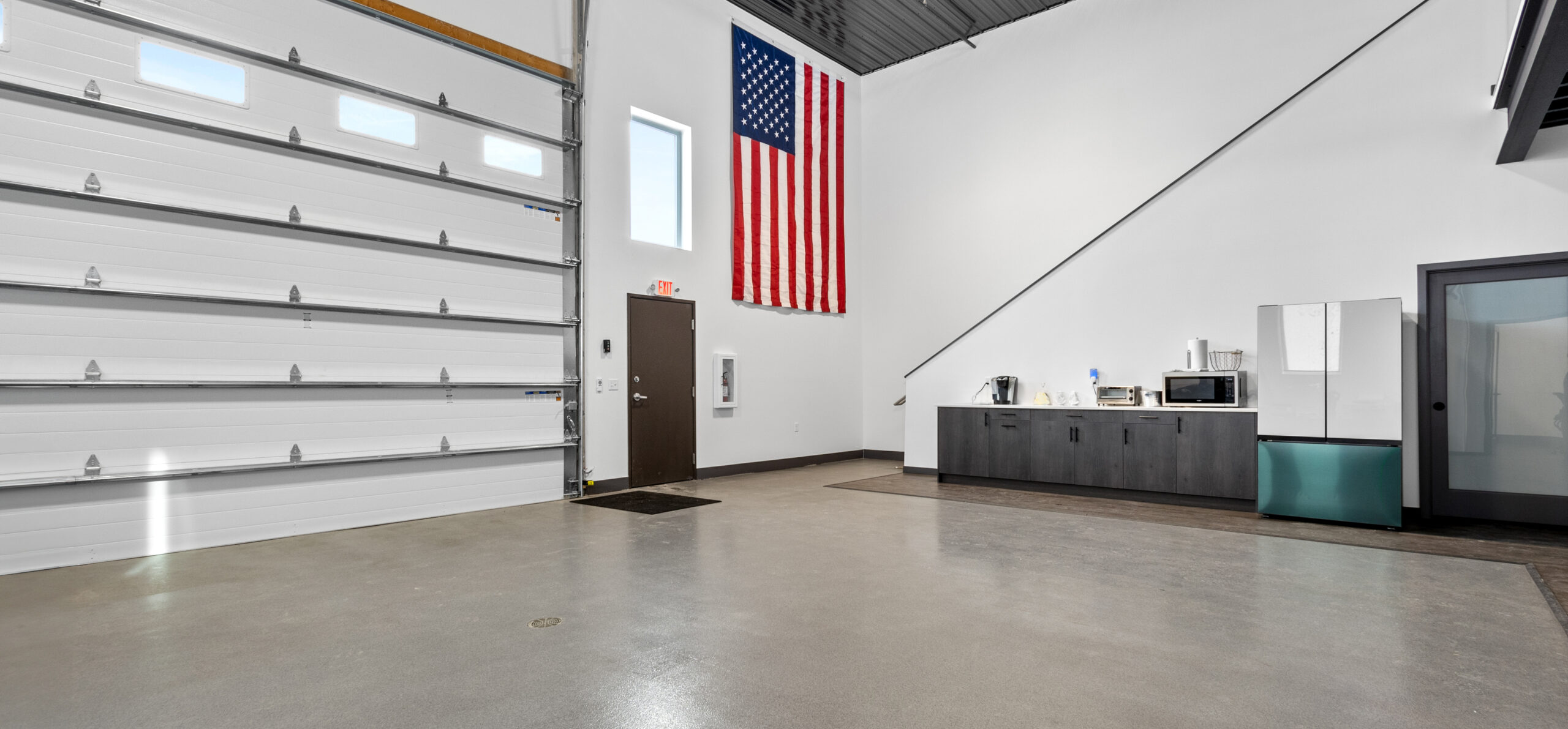 A garage space with cabinets and a refrigerator.