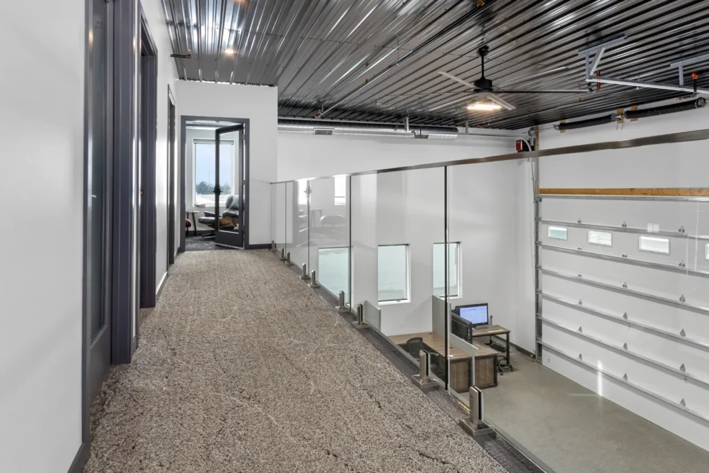 A mezzanine hallway, overlooking office space below.